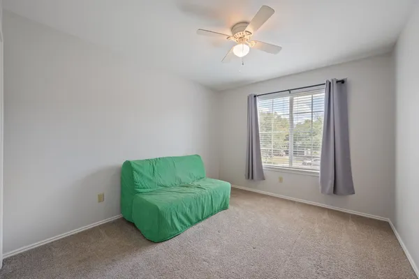 an empty room with a window and a ceiling fan