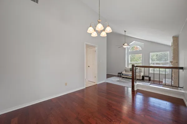 a view of an empty room with wooden floor and a large window