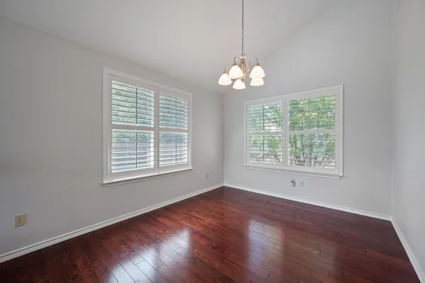 a view of a room with wooden floors and chandelier