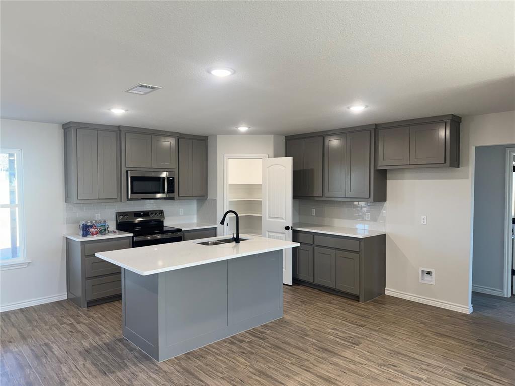 1004 Morgan Court Springtown, TX 76082 - Photo 2 of 8 a kitchen with stainless steel appliances granite countertop a sink stove and refrigerator