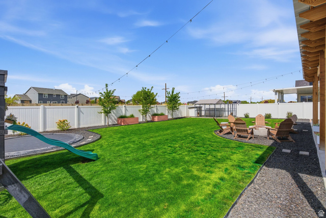 596 South Meade Street Mapleton, UT 84664 - Photo 37 of 38 Fenced backyard with a residential view, a patio, an outdoor fire pit, and a playground