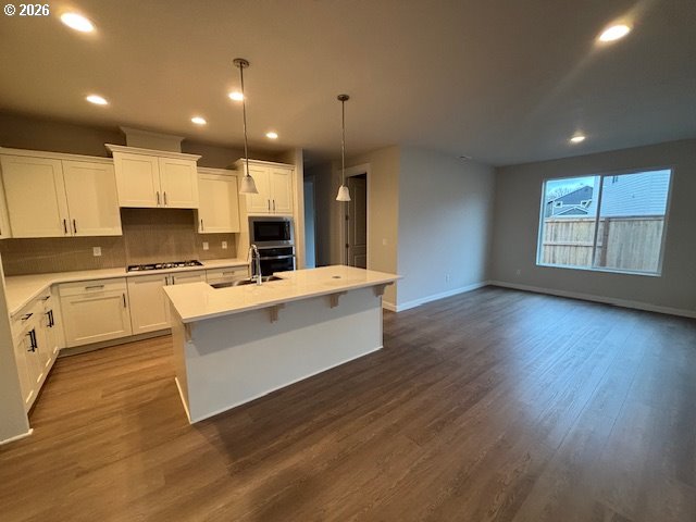1585 Young Street Lafayette, OR 97127 - Photo 9 of 23 a large white kitchen with kitchen island a sink wooden floor and a refrigerator
