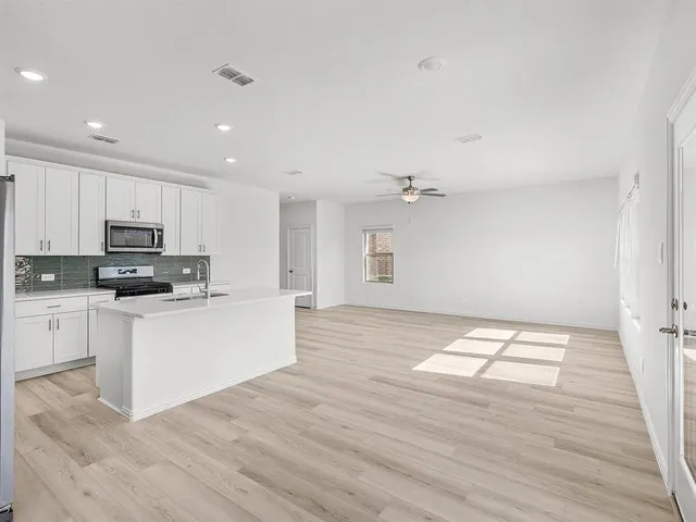 a kitchen with stainless steel appliances a refrigerator sink and stove