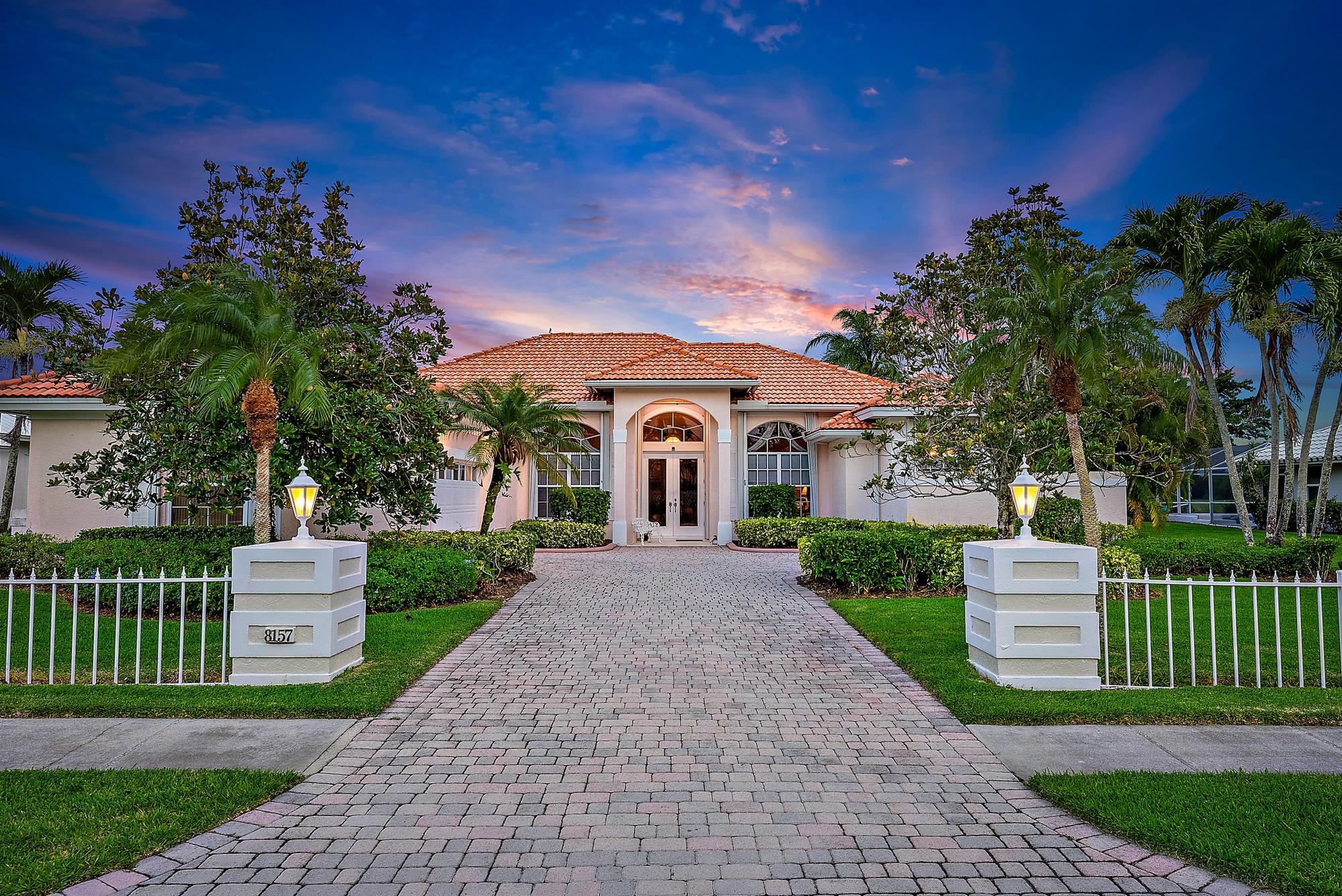 8157 Southeast Double Tree Drive Hobe Sound, FL 33455 - Photo 1 of 46 a front view of a house with a garden and yard
