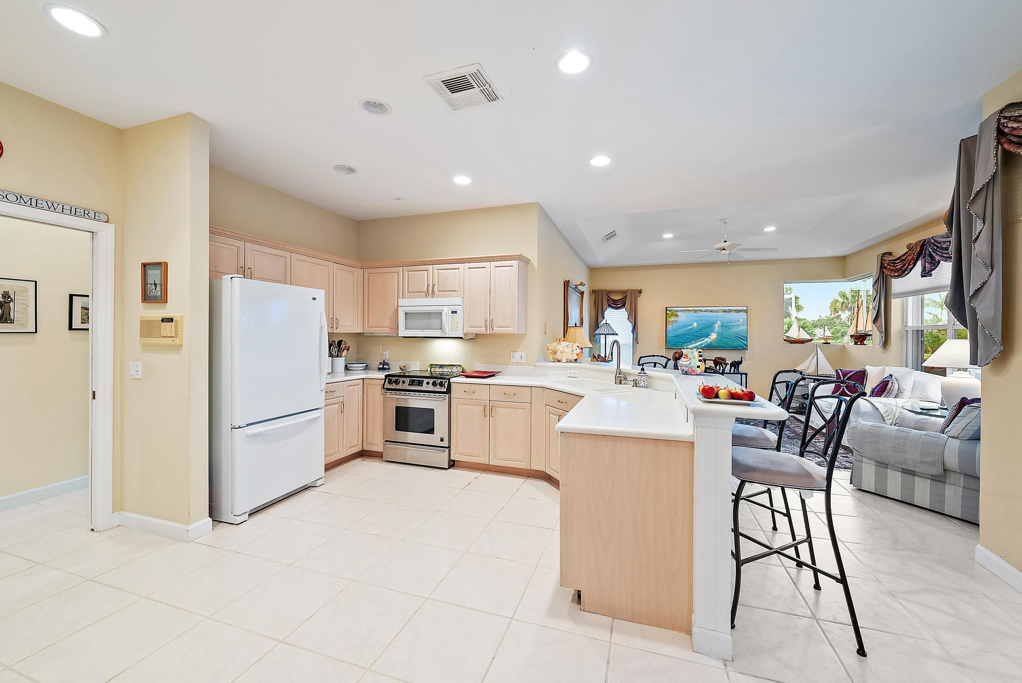 8157 Southeast Double Tree Drive Hobe Sound, FL 33455 - Photo 12 of 46 a living room with stainless steel appliances furniture a rug and a kitchen view