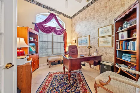 a living room with furniture a bookshelf and a window