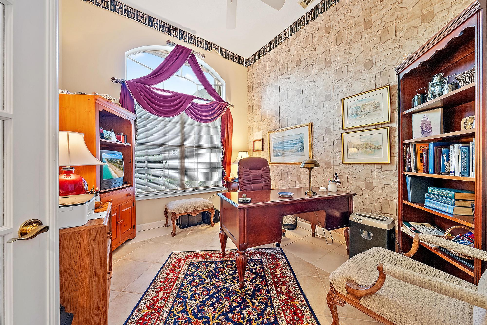 8157 Southeast Double Tree Drive Hobe Sound, FL 33455 - Photo 15 of 46 a living room with furniture a bookshelf and a window