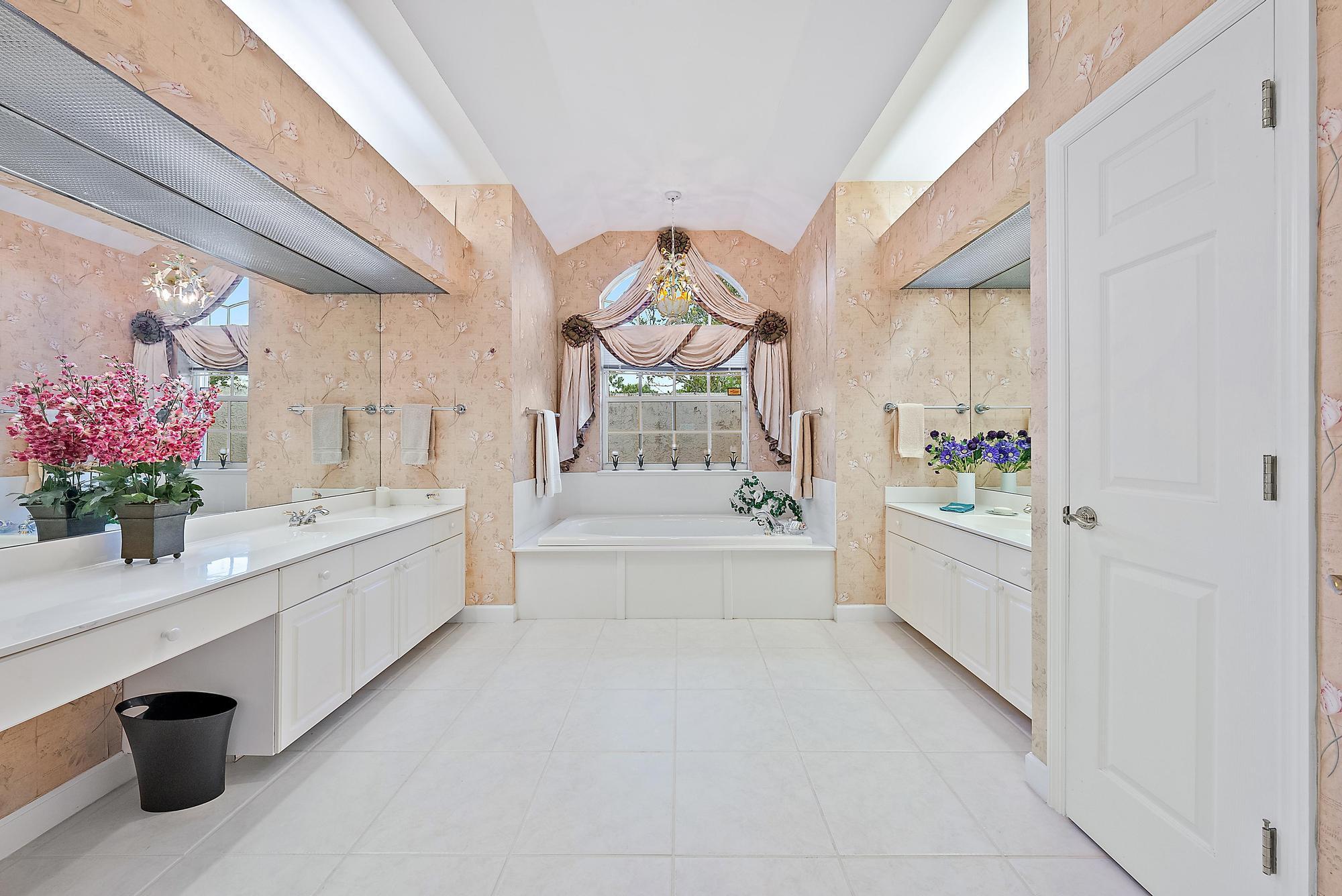 8157 Southeast Double Tree Drive Hobe Sound, FL 33455 - Photo 18 of 46 a bathroom with a tub sink and mirror