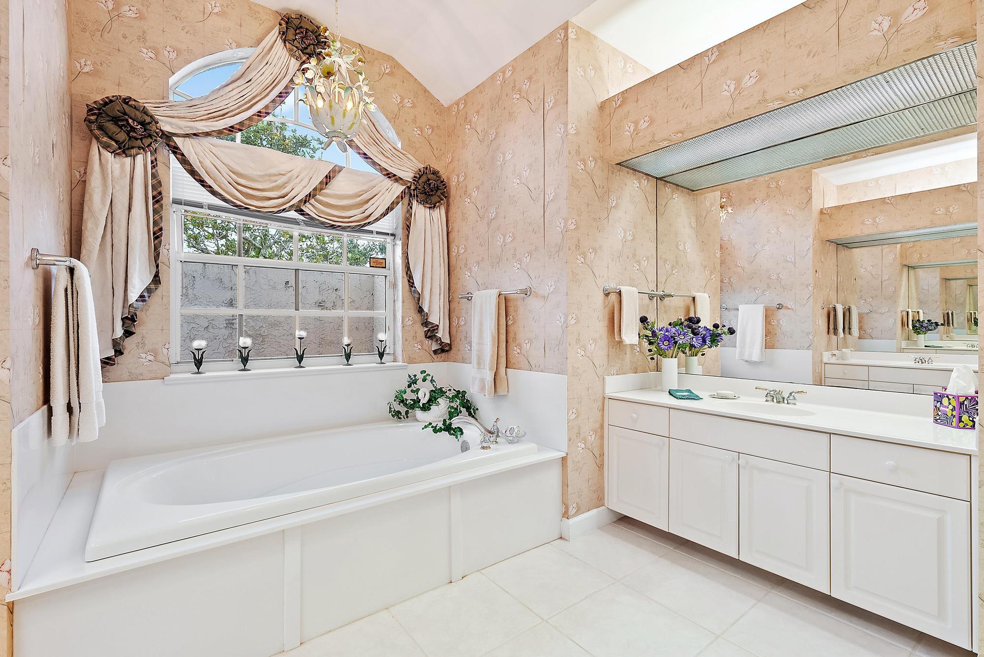8157 Southeast Double Tree Drive Hobe Sound, FL 33455 - Photo 19 of 46 a bathroom with a bathtub sink and mirror