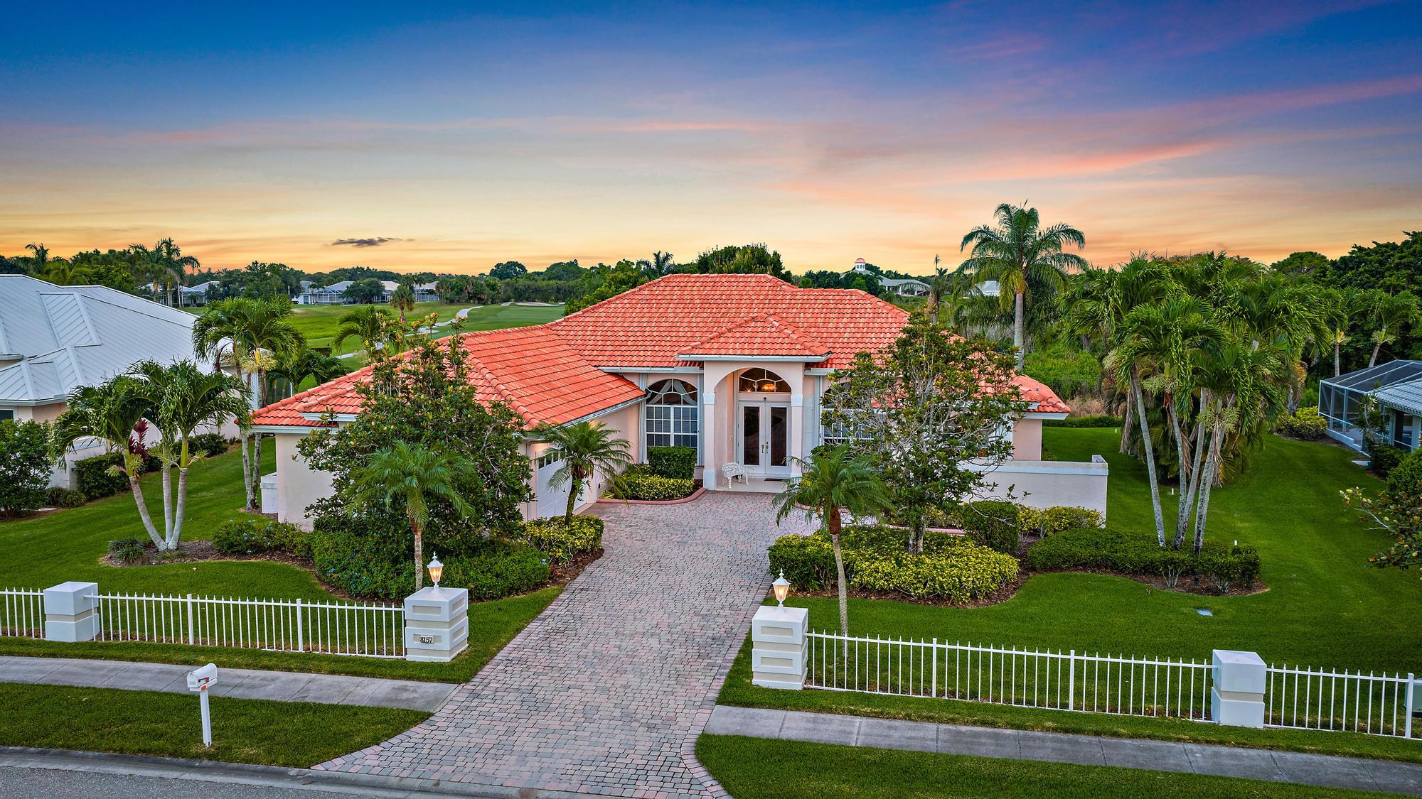 8157 Southeast Double Tree Drive Hobe Sound, FL 33455 - Photo 2 of 46 a view of a house with a big yard and potted plants