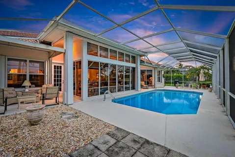 a view of a house with a swimming pool and sitting area