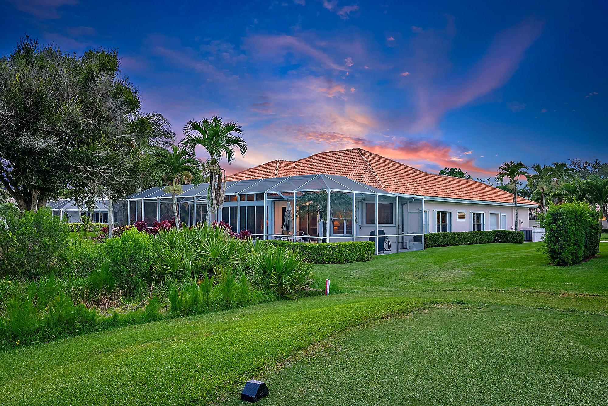 8157 Southeast Double Tree Drive Hobe Sound, FL 33455 - Photo 30 of 46 a front view of a house with a garden