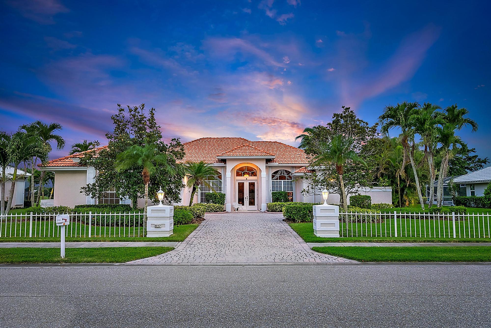 8157 Southeast Double Tree Drive Hobe Sound, FL 33455 - Photo 32 of 46 a front view of a house with a garden and trees