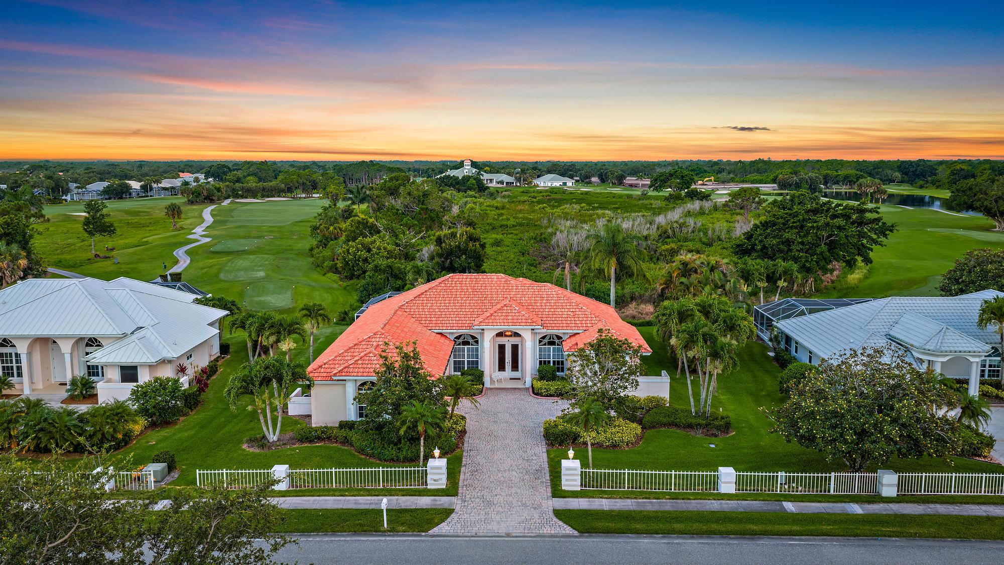 8157 Southeast Double Tree Drive Hobe Sound, FL 33455 - Photo 33 of 46 a view of a big house with a big yard and large trees