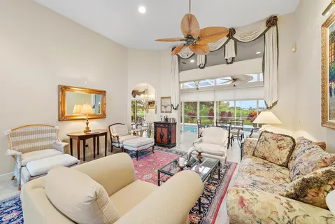 a living room with furniture a chandelier and a large window
