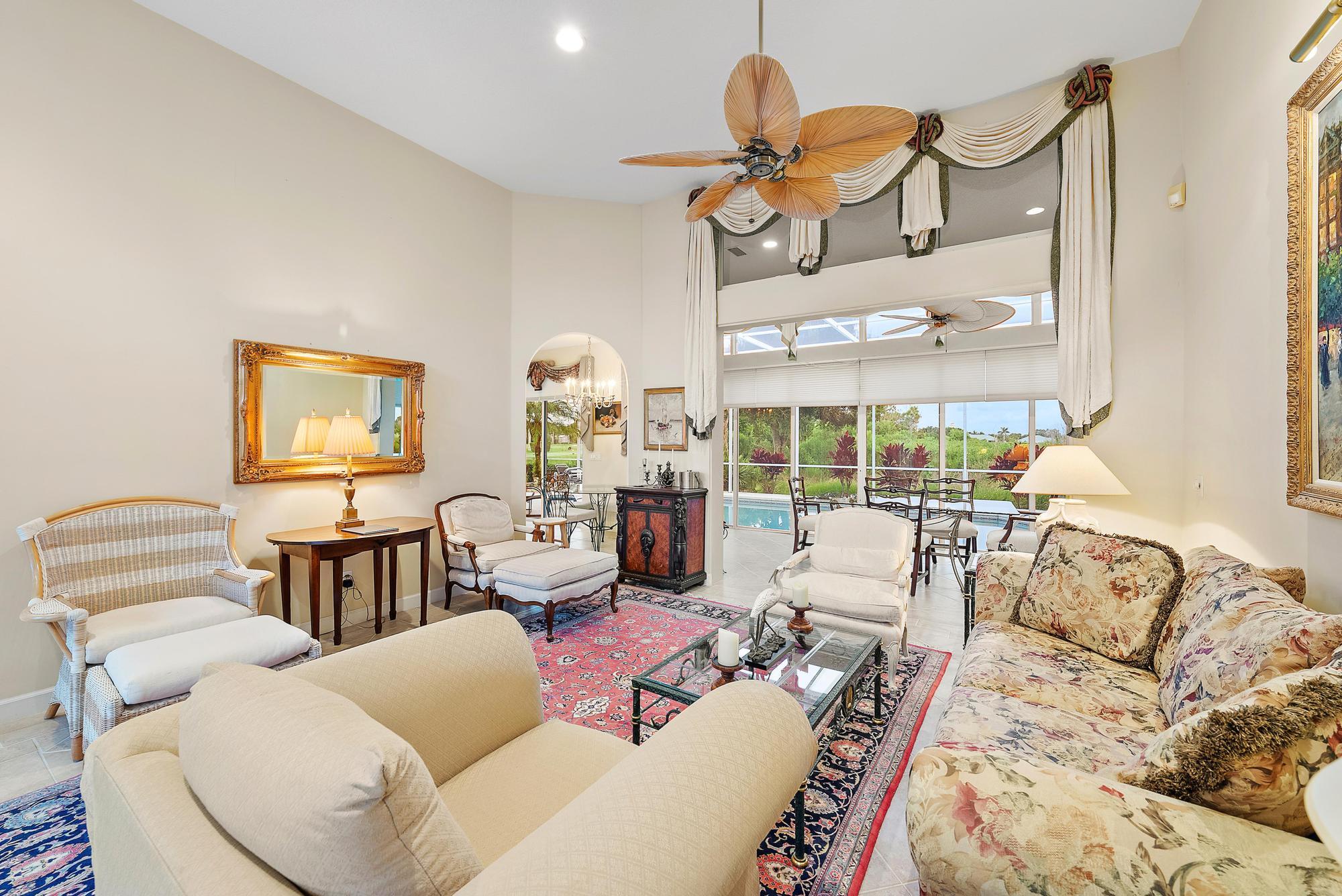 8157 Southeast Double Tree Drive Hobe Sound, FL 33455 - Photo 6 of 46 a living room with furniture a chandelier and a large window