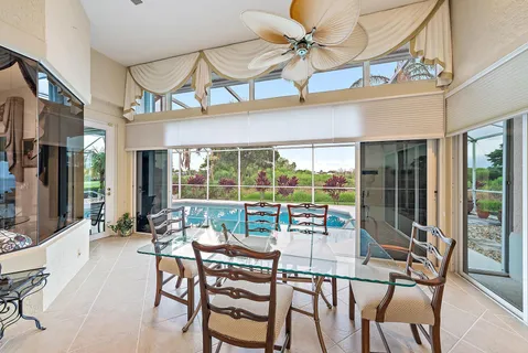 a view of a dining room with furniture large windows and a chandelier