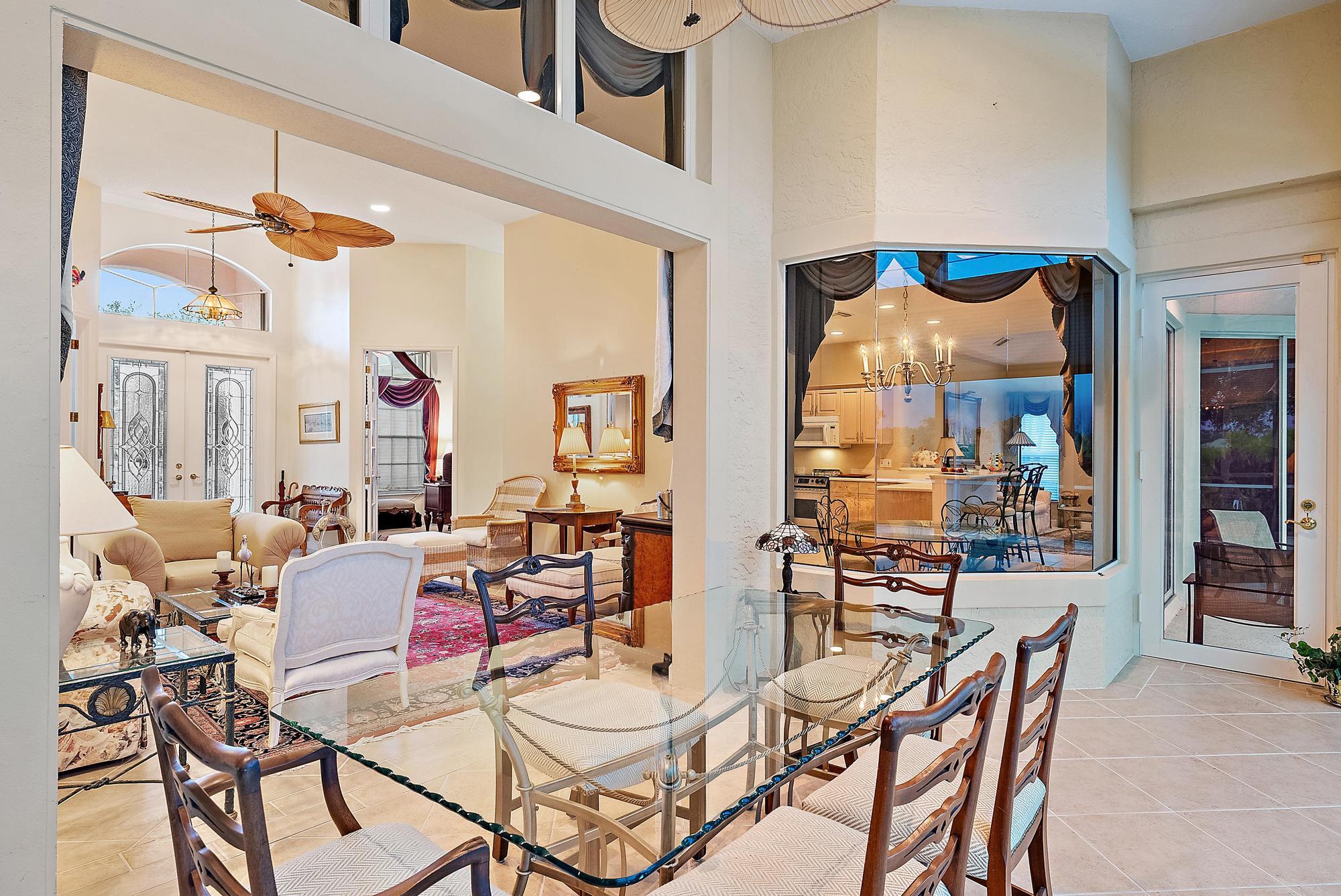 8157 Southeast Double Tree Drive Hobe Sound, FL 33455 - Photo 9 of 46 a view of a dining room with furniture wooden floor and a chandelier