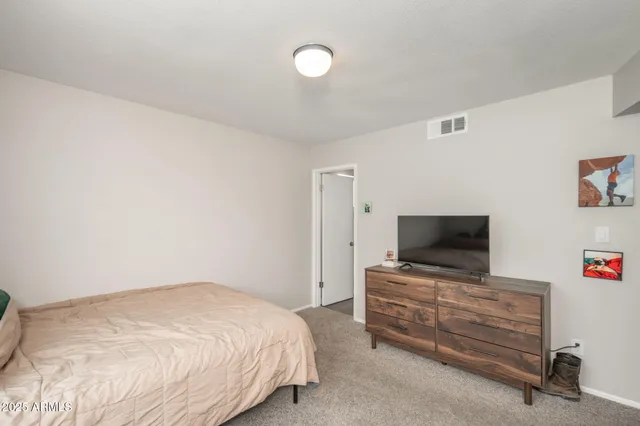 a bedroom with a bed and flat screen tv