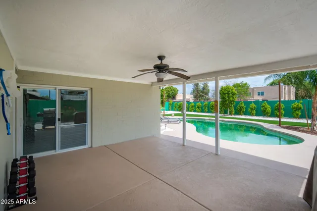 a view of an empty room with floor to ceiling windows and a yard