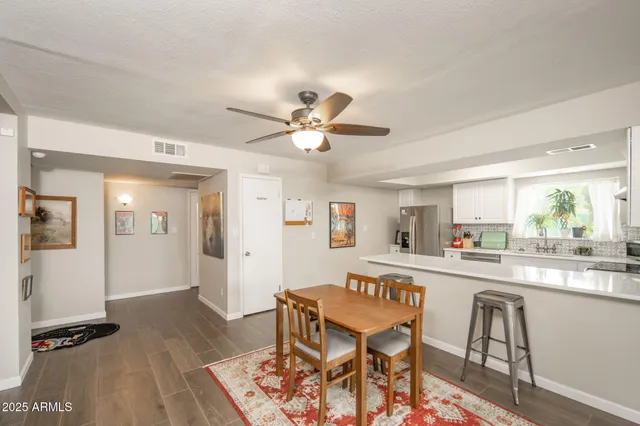 a kitchen with a dining table chairs and white cabinets