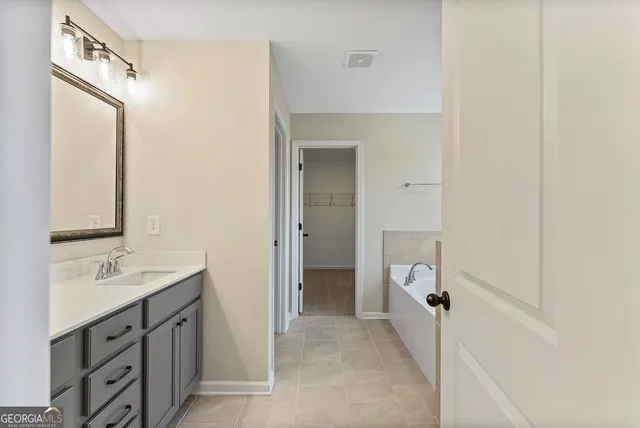 a spacious bathroom with a double vanity sink a mirror and a