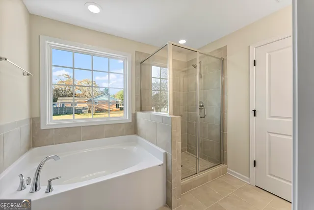 a bathroom with a large tub a shower and view