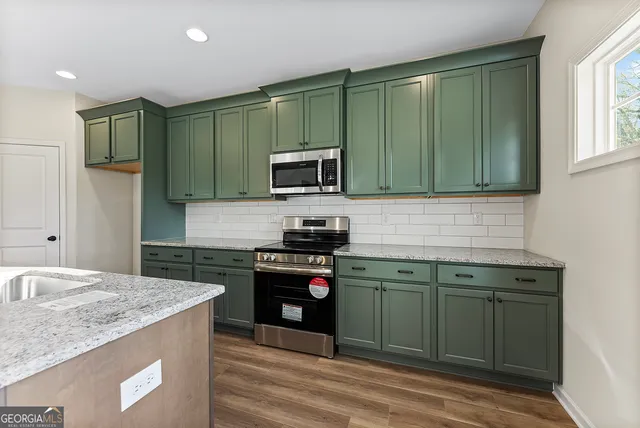 a kitchen with granite countertop cabinets stainless steel appliances and a sink