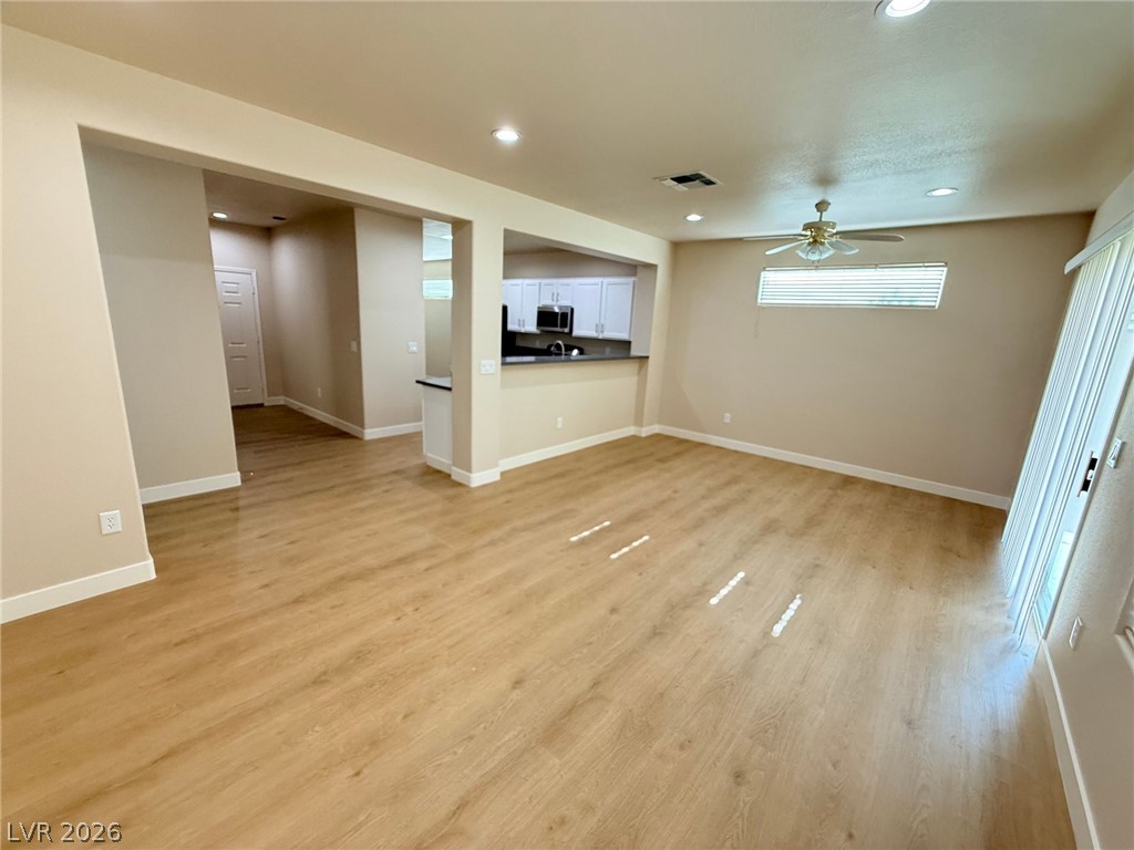 3036 Fort Stanwix Road Henderson, NV 89052 - Photo 14 of 18 Warm wood floors and recessed lighting enhance this open concept interior layout.