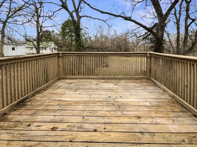 a view of balcony with wooden floor and fence
