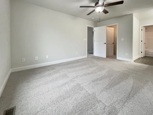 an empty room with a ceiling fan and a window
