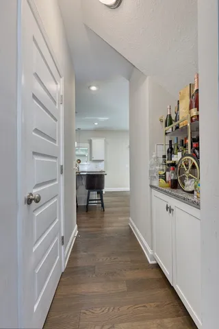 a view of a hallway to a livingroom and a staircase