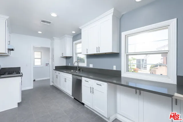 a kitchen with granite countertop white cabinets and white appliances