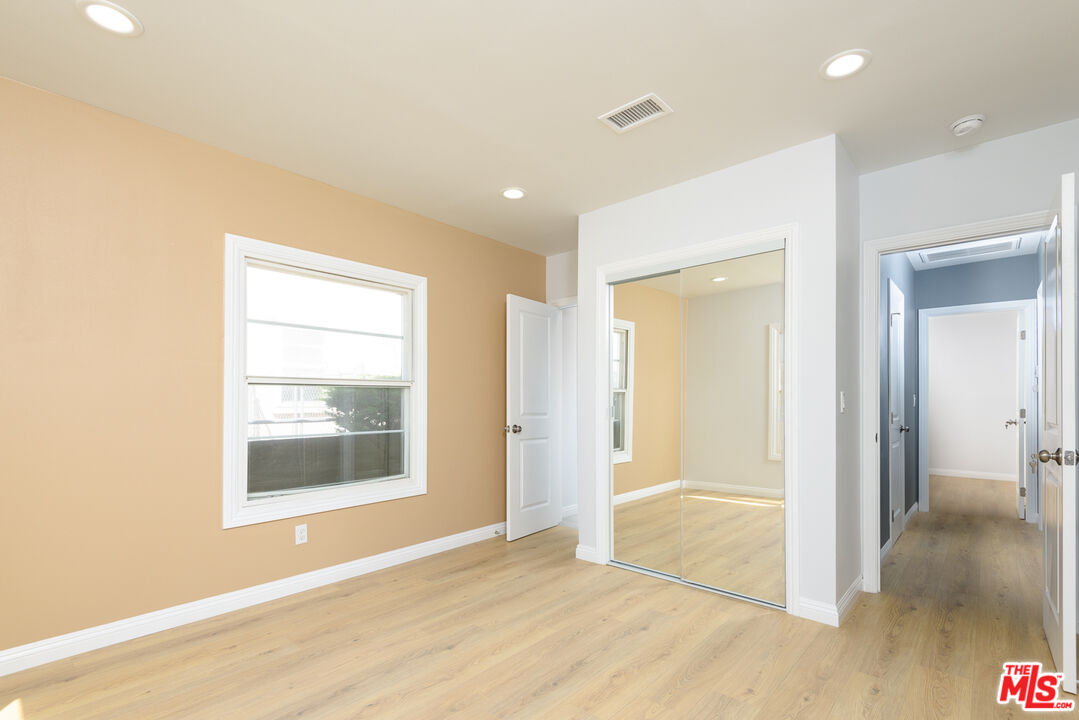 2107 West 84th Place Los Angeles, CA 90047 - Photo 16 of 25 a view of an empty room with wooden floor and a window