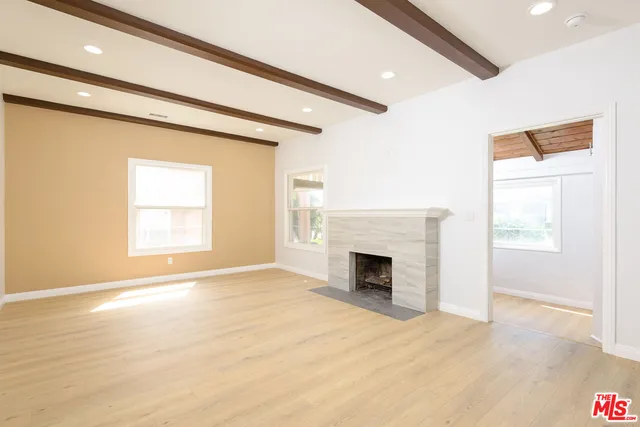 a view of an empty room with a fireplace and a window