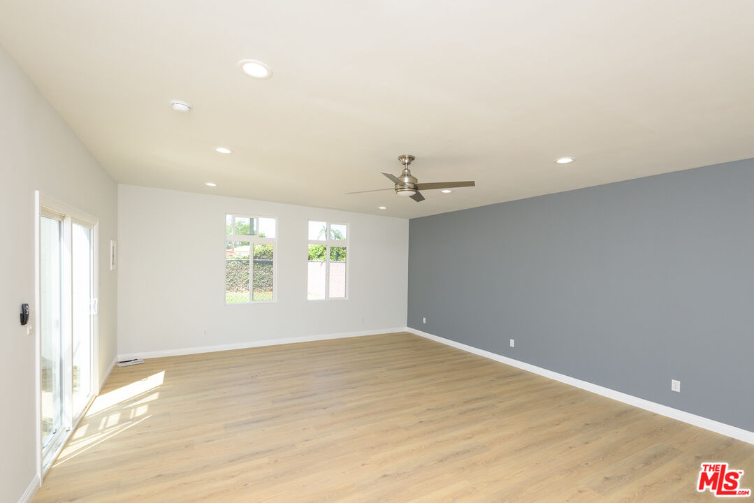 2107 West 84th Place Los Angeles, CA 90047 - Photo 21 of 25 an empty room with windows and ceiling fan