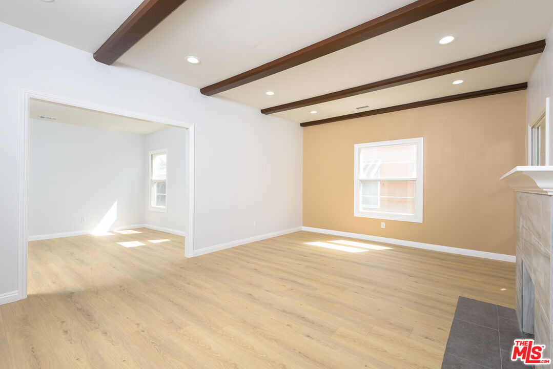 2107 West 84th Place Los Angeles, CA 90047 - Photo 5 of 25 a view of an empty room with wooden floor and a window
