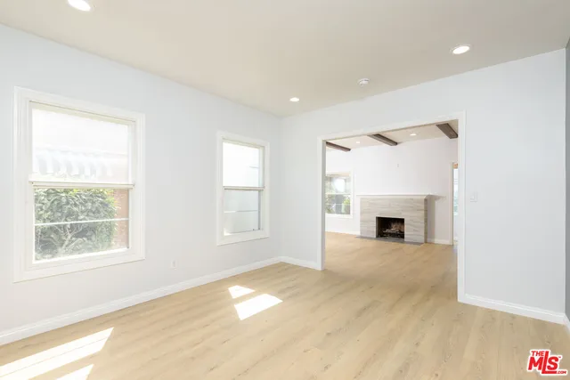 a view of empty room with wooden floor and fireplace