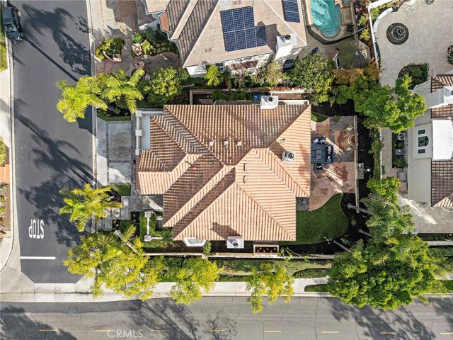 an aerial view of residential houses with outdoor space and trees