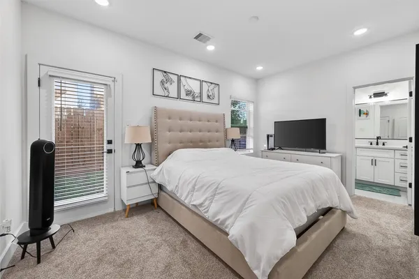 a large bedroom with a bed and a flat screen tv