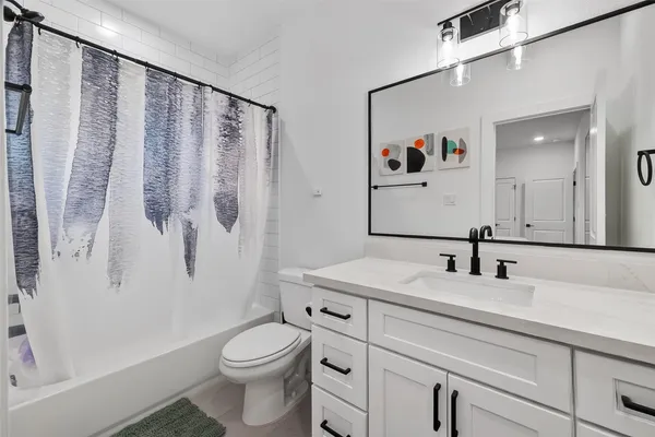 a bathroom with a sink a toilet and shower curtain