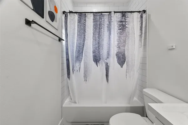 a bathroom with a shower curtain and a toilet