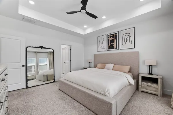 a bedroom with a large bed and a chandelier