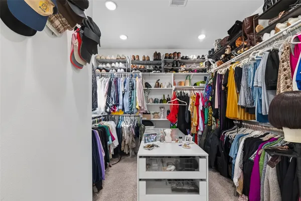 a view of walk in closet with clothes