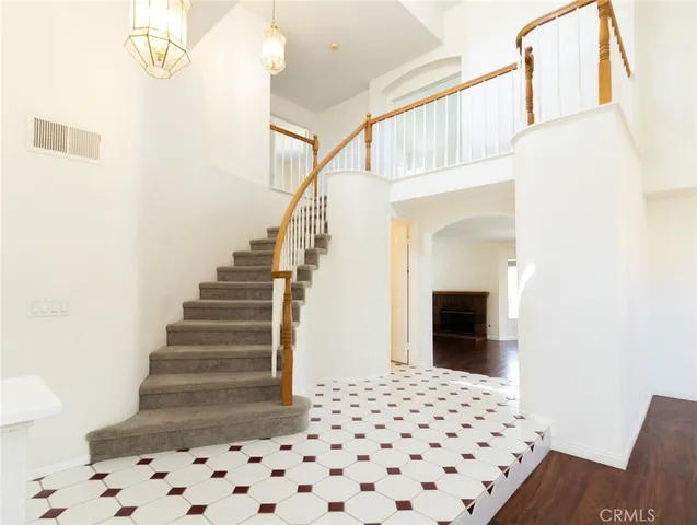 a view of an empty room with wooden floor and white walls