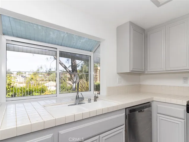 a kitchen with sink a microwave and cabinets