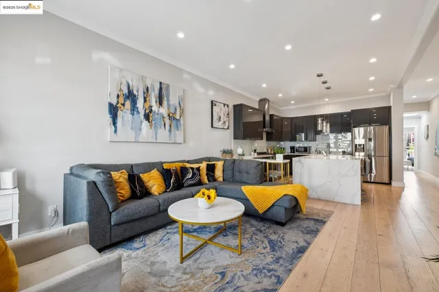 a kitchen with stainless steel appliances granite countertop a refrigerator a sink a stove and white cabinets