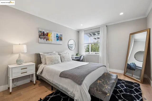 a spacious bedroom with a bed a chair and potted plant on the table