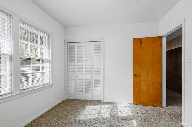 a bedroom with a bed dresser and a window