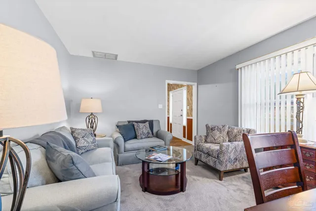 a view of a dining room with furniture a chandelier and wooden floor